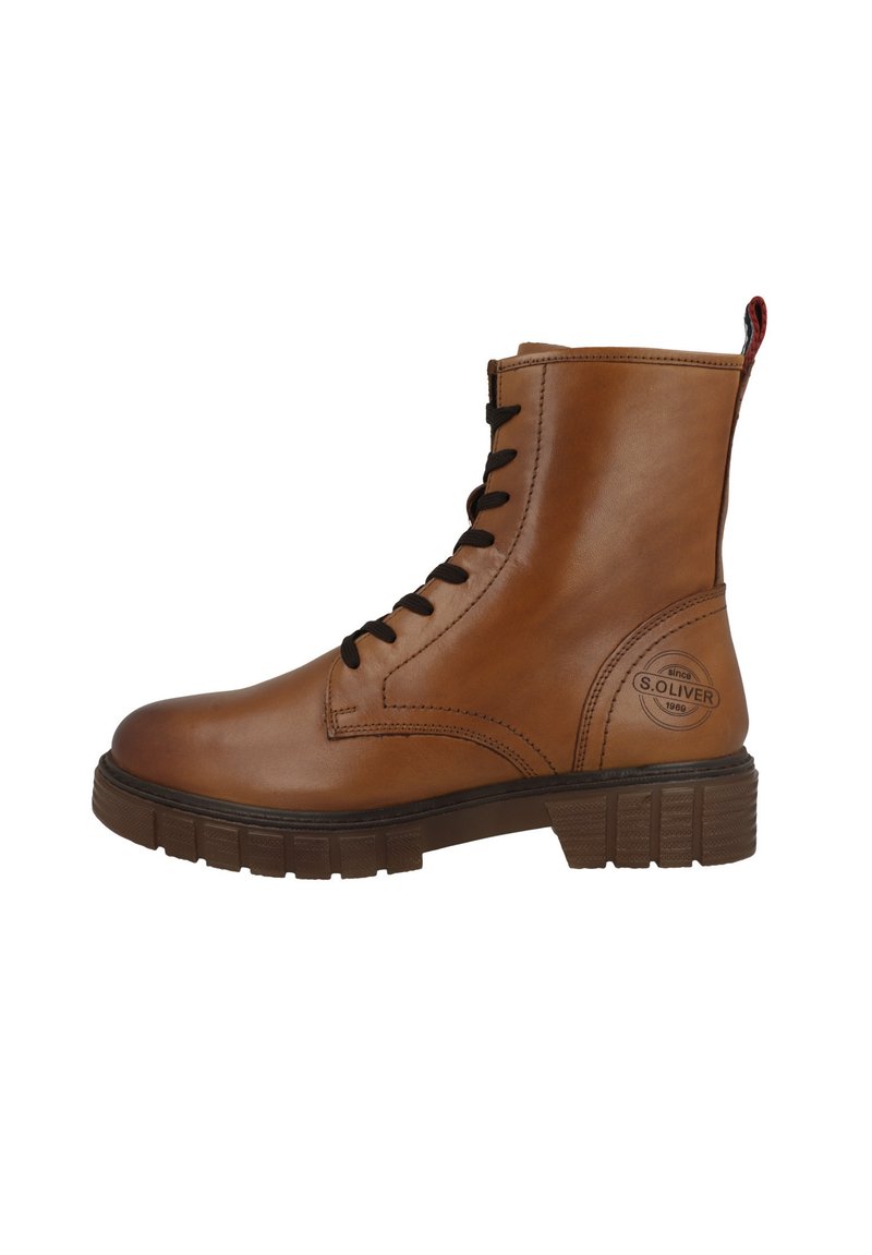 Botas de cuero marrón hasta el tobillo con puntera redonda, cordones negros y suela de goma texturizada. Presenta un detalle con el logo en el lateral y una pestaña de agarre.
