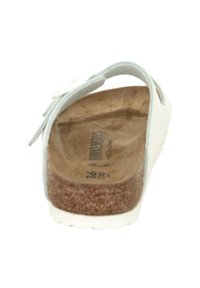 Infradito bianche con suola in sughero, cinturino regolabile e texture liscia. Caratterizzano una forma sagomata e un design con punta arrotondata.
