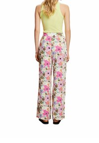 Bloemen wijdvallende broek in pastelkleuren, met roze, paarse en beige bloemen op een witte achtergrond. Elastische tailleband, lichtgewicht stof.