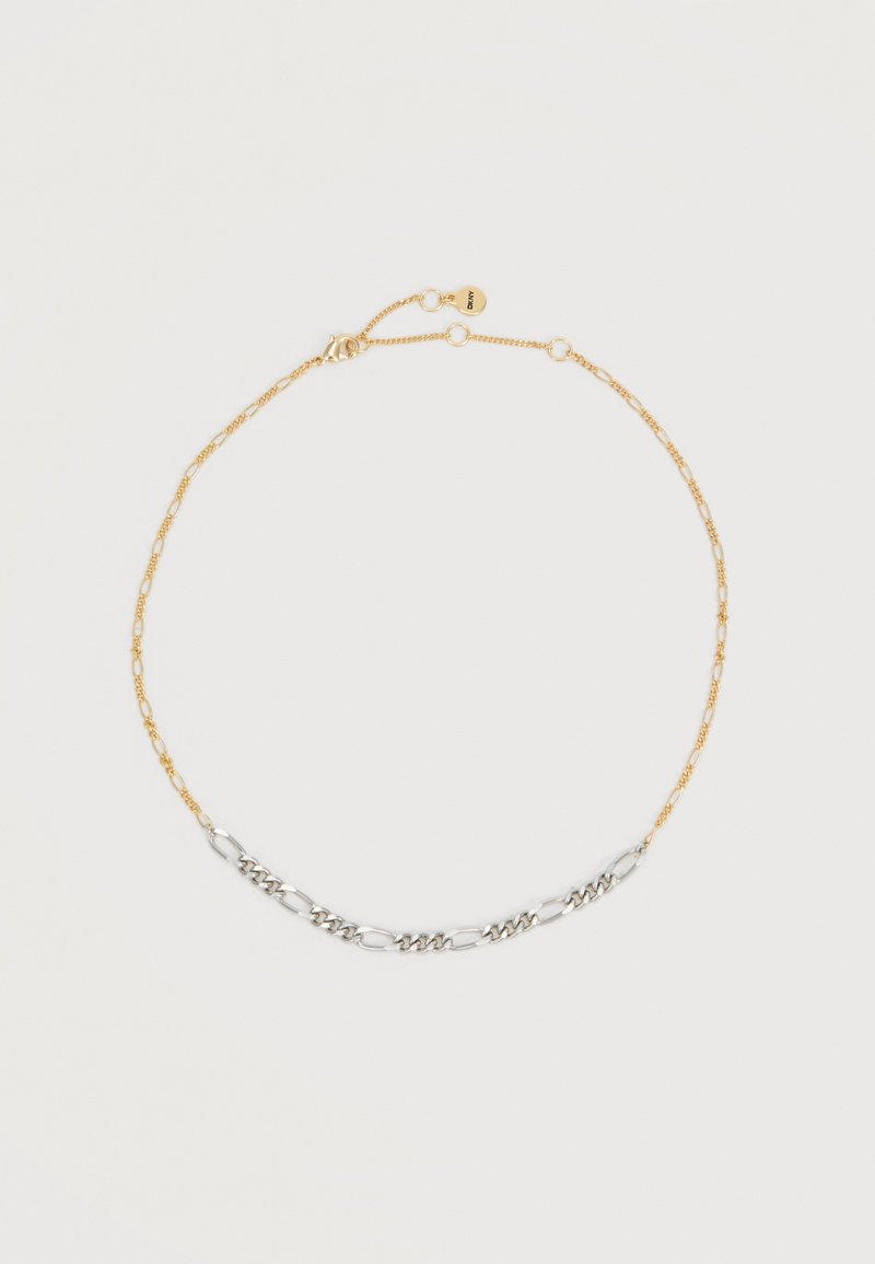 Collier délicat en chaîne d'or avec une section de maillons en chaîne argentée et un petit fermoir rond en or avec une étiquette attachée.