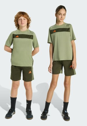 Des t-shirts de sport verts avec des rayures horizontales vert foncé, assortis à des shorts. Présentent des accents de logo orange et des détails à trois bandes.