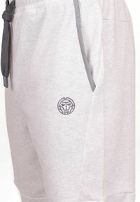 Helle graue Shorts aus weichem Stoff, mit einem Kordelzugbund, seitlichen Taschen und einem kleinen geprägten Logo am linken Oberschenkel.