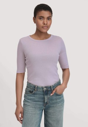 Hellblaues, eng anliegendes T-Shirt mit rundem Ausschnitt und kurzen Ärmeln, kombiniert mit hochgeschnittenen blauen Jeans. Weicher Stoff.