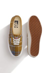 Yellow and blue plaid canvas sneakers with white laces and rubber soles featuring a waffle pattern. Logo visible on the insole.