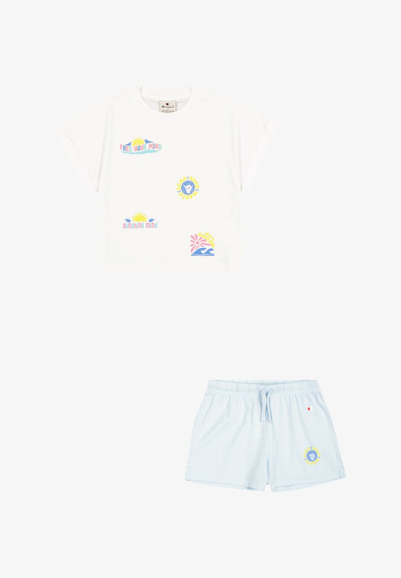 Camiseta de algodón blanca con estampados gráficos en tonos pastel y mangas enrolladas, combinada con pantalones cortos azul claro con cinturilla elástica y logo.