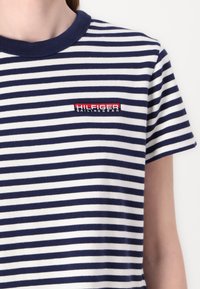 Jūrinės ir baltos dryžuotos medvilninės marškinėliai su žakardo apykakle ir mažuoju siuvinėtų "HILFIGER Sailing Gear" logotipu krūtinėje.