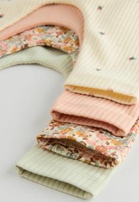 Set van vier ribbelstofstukken in beige, roze en lichtgroen, met bloemenpatronen op sommige. Elk heeft een zachte, gestructureerde afwerking.