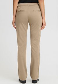 Pantaloni beige su misura con taglio dritto, due tasche posteriori e una texture di tessuto liscia, rifiniti con una cintura classica.
