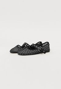 Ballerines noires avec un design clouté, bout rond et strap ajustable. Fabriquées dans un matériau texturé avec une doublure intérieure lisse.