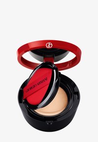 Compact de fond de teint cushion Giorgio Armani avec un couvercle rouge brillant, une base noire et un applicateur en tissu rouge inclus. La texture est lisse et crémeuse.