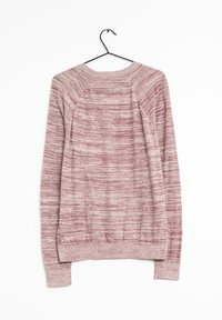 Różowy i biały dzianinowy sweter z długim rękawem, wiszący na czarnym wieszaku na białym tle.