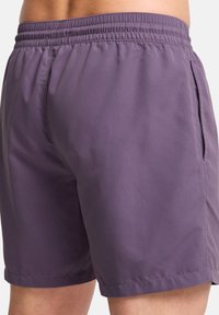 Πολύχρωμα ελαστικά μαγιό κολύμβησης με λεία, ελαφριά υφή. Διαθέτει πλευρικές τσέπες και απλές ραφές κατά μήκος των ραφών.