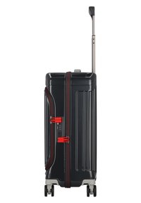 Schwarzer Hartschalenkoffer mit roten Akzenten, zwei Reißverschlüssen, einem Kombinationsschloss und einem ausziehbaren Griff. Vier Rollen für einfache Mobilität.