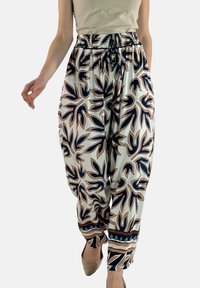 Loszittende broek van lichtgewicht stof met een bloemmotief in marineblauw en beige, voorzien van een elastische tailleband en decoratieve zoomaccenten.