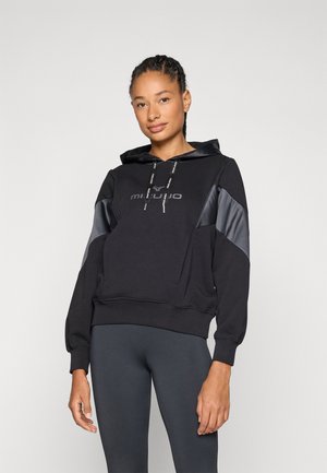 Black hoodie with a shiny black panel design, front pocket, adjustable drawstrings, and logo text. Worn with dark leggings.