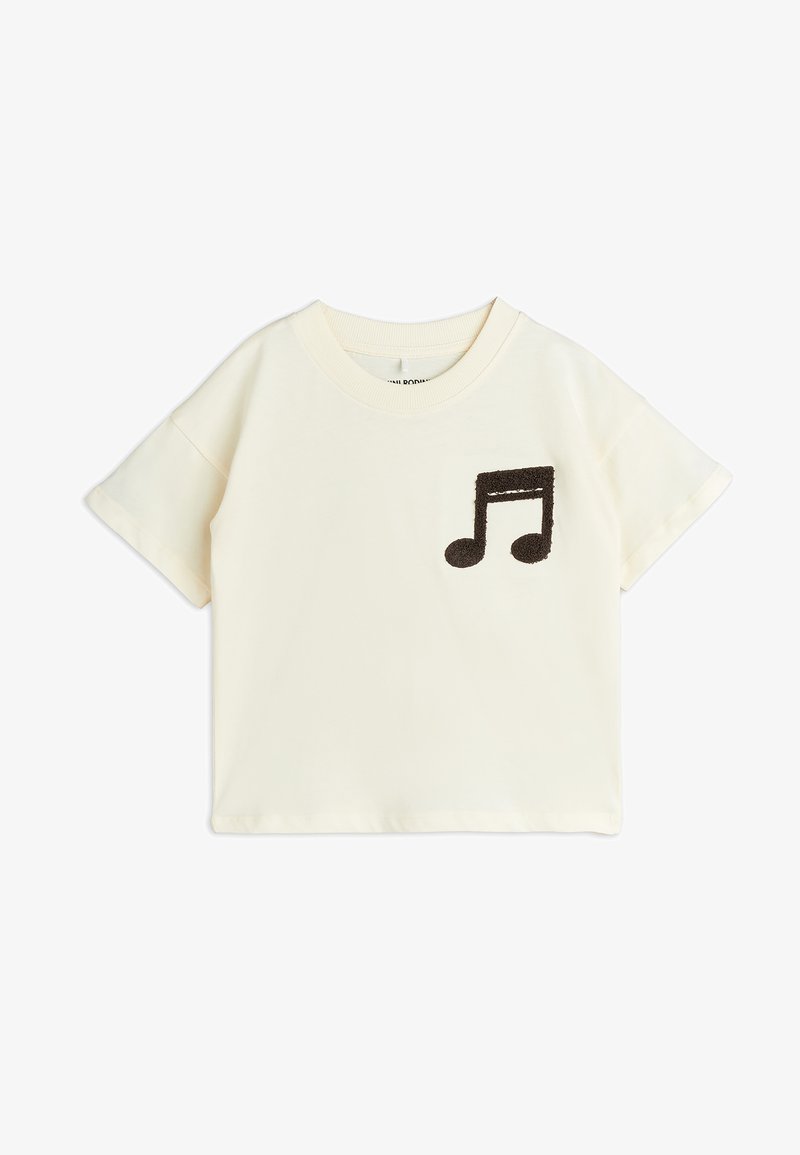 Cream-colored short-sleeve t-shirt made of soft fabric, featuring a fuzzy brown music note applique on the front. Straight hem.