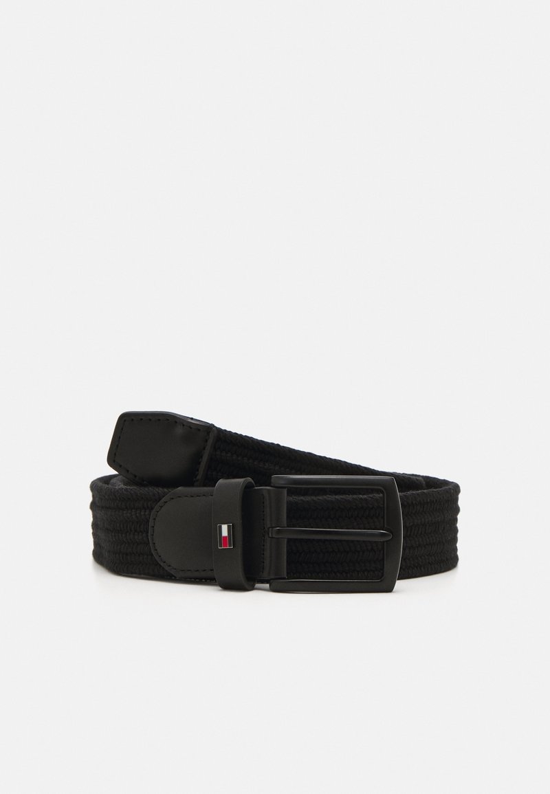 Ceinture en tissu tissé noir avec une boucle métallique rectangulaire noire et un petit logo rectangulaire rouge, blanc et bleu sur une boucle en cuir.