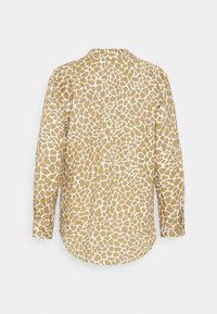 Camisa abotoada em castanho dourado com padrão de girafa branca. Mangas longas, colarinho e bainha curva. Tecido macio com um acabamento texturizado.