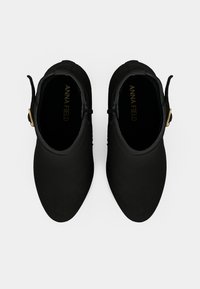 Juodi kulkšniniai botai su lygiu, matinio paviršiaus apdaila. Savybė - dekoratyvi sagtis ir apvalios nosies dizainas. Viduje yra prekės ženklo etiketė.