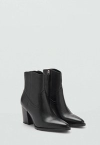 Schwarze Leder-Stiefeletten mit spitzem Zeh, schmalem Absatz und seitlichem Reißverschluss. Texturierte Oberfläche und dekorative Nähte an den Seiten.