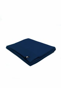 Coperta blu navy con un motivo testurizzato, piegata ordinatamente. Presenta un piccolo etichetta nera in un angolo. Tessuto morbido e versatile.