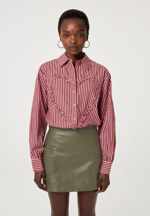 Gestreepte blouse met een hartvormige ruches in roze en bordeauxrood, gecombineerd met een aansluitende olijfgroene neplederen rok.