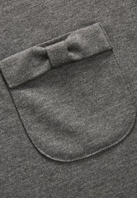 Grauer Sweatshirtstoff mit einer runden Tasche und einem Stoffband-Akzent, der eine weiche Textur und ein dezentes Melange-Muster zeigt.