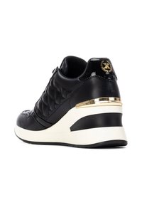 Zapatilla de cuero negro con textura acolchada, acento dorado cerca del talón y una suela media blanca. Presenta una puntera redonda y cuello acolchado.