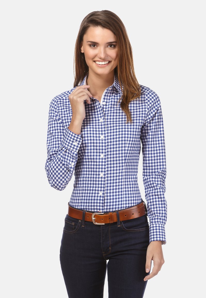 Blauw-wit geruit overhemd met lange mouwen, button-down kraag en manchet. Gecombineerd met een leren bruine riem en donkere jeans.