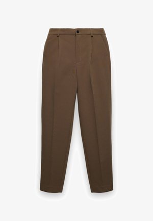 Pantalon marron sur mesure avec passants de ceinture, fermeture à boutons sur le devant, poches latérales et plis repassés le long des jambes, sur fond blanc.