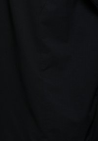 Sort stof med et struktureret mønster på den ene side. Materialet er glat, og designet har tonale variationer i vævningen.
