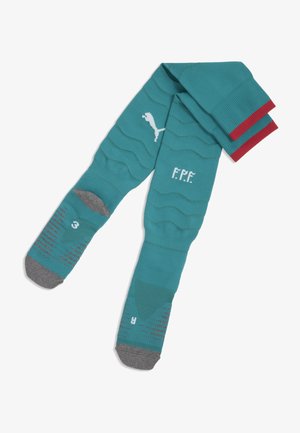 Turkusowe skarpety piłkarskie z czerwonymi akcentami na górze. Posiadają teksturowane wzory, logo oraz wzmocnione szare części na palcach i pięcie. Rozmiar oznaczony jako 3.