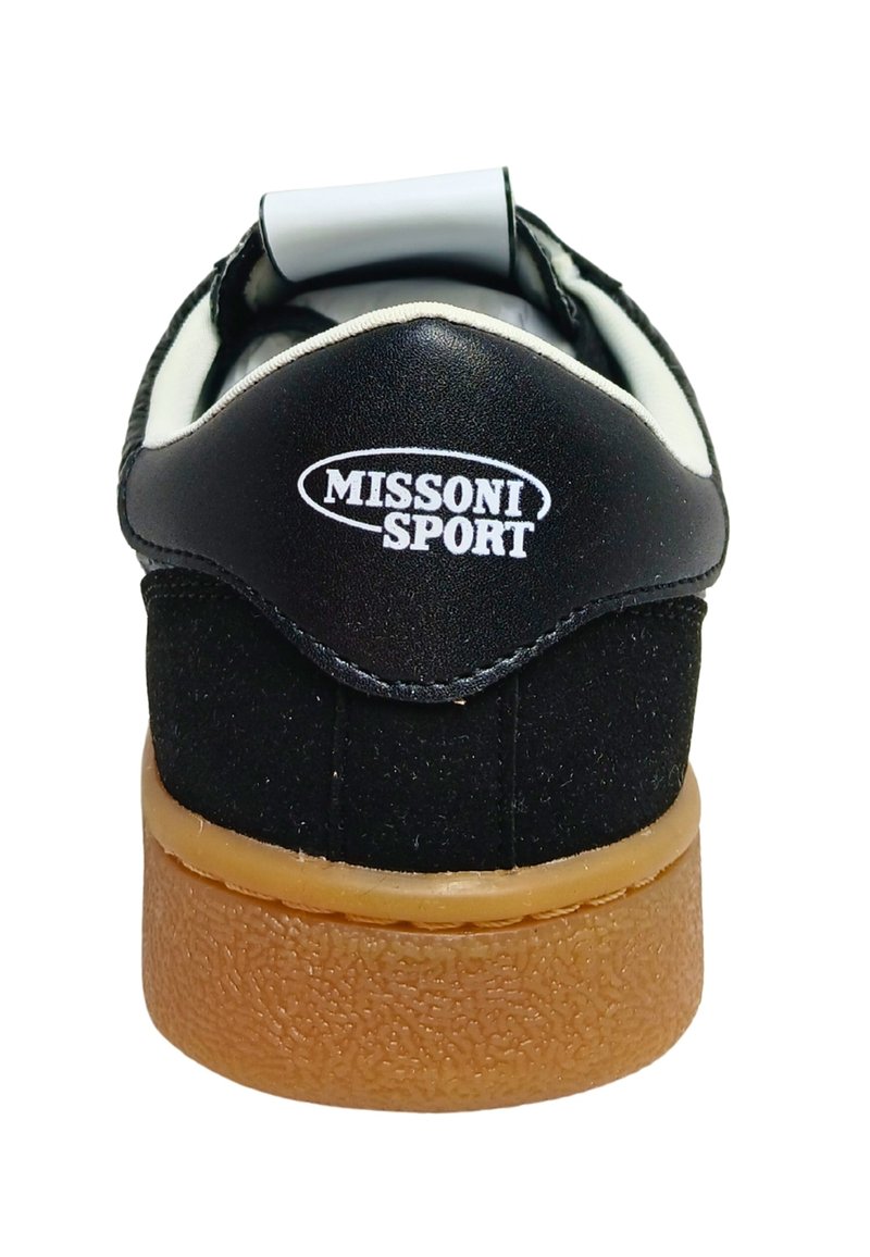 Chaussure de sport noire avec une tige en daim et cuir, présentant un logo blanc, un talon rond et une semelle extérieure en caoutchouc gomme texturée.