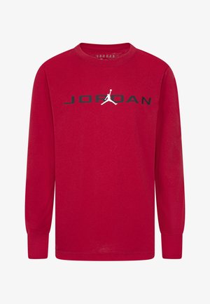 Raudona ilgomis rankovėmis marškinėliai, pagaminti iš medvilnės, su žodžiu "JORDAN" juoda spalva virš balto Jumpman logotipo priekyje.