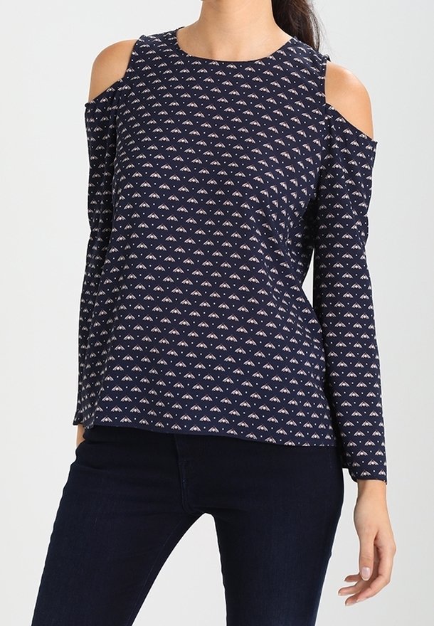 Navy long-sleeve top with cold shoulder cutouts, featuring a repeated geometric pattern in light colors and a rounded neckline.