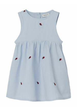 Lichtblauw katoenen jurk met een ronde hals en mouwloos ontwerp. Kenmerkt zich door rode geborduurde lieveheersbeestjes aan de voorkant en een gerimpelde taille.