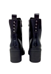 Stivali neri alla caviglia con finitura in pelle liscia, dotati di tacco a blocco, lati elasticizzati e borchie decorative argentate sul retro.