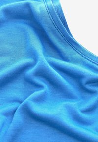 Tessuto di cotone blu con una superficie liscia e una leggera elasticità, caratterizzato da una scollatura a barca e un morbido drappeggio.