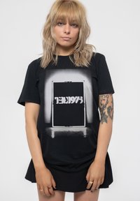Black cotton t-shirt featuring a large graphic of a door with white accent text. The shirt has a relaxed fit and short sleeves.