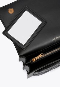 Sac à main en cuir noir à la texture lisse, doté d'une fermeture éclair, d'une fenêtre d'identification transparente et d'accents de quincaillerie dorée.