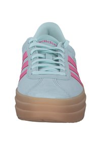 Ljusblå mockaskor med rosa tre ränder, rund tå och tjock tan-sula. Har vita snören och en vadderad krage för komfort.