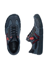 Chaussures décontractées bleu foncé avec des lacets noirs, des détails de fermeture éclair rouges sur le côté et des semelles épaisses noires avec un motif en zigzag.
