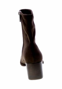 Stivale ankle in suede marrone con chiusura a zip, forma affusolata e tacco impilato. Il tessuto testurizzato e la finitura liscia accentuano il design.