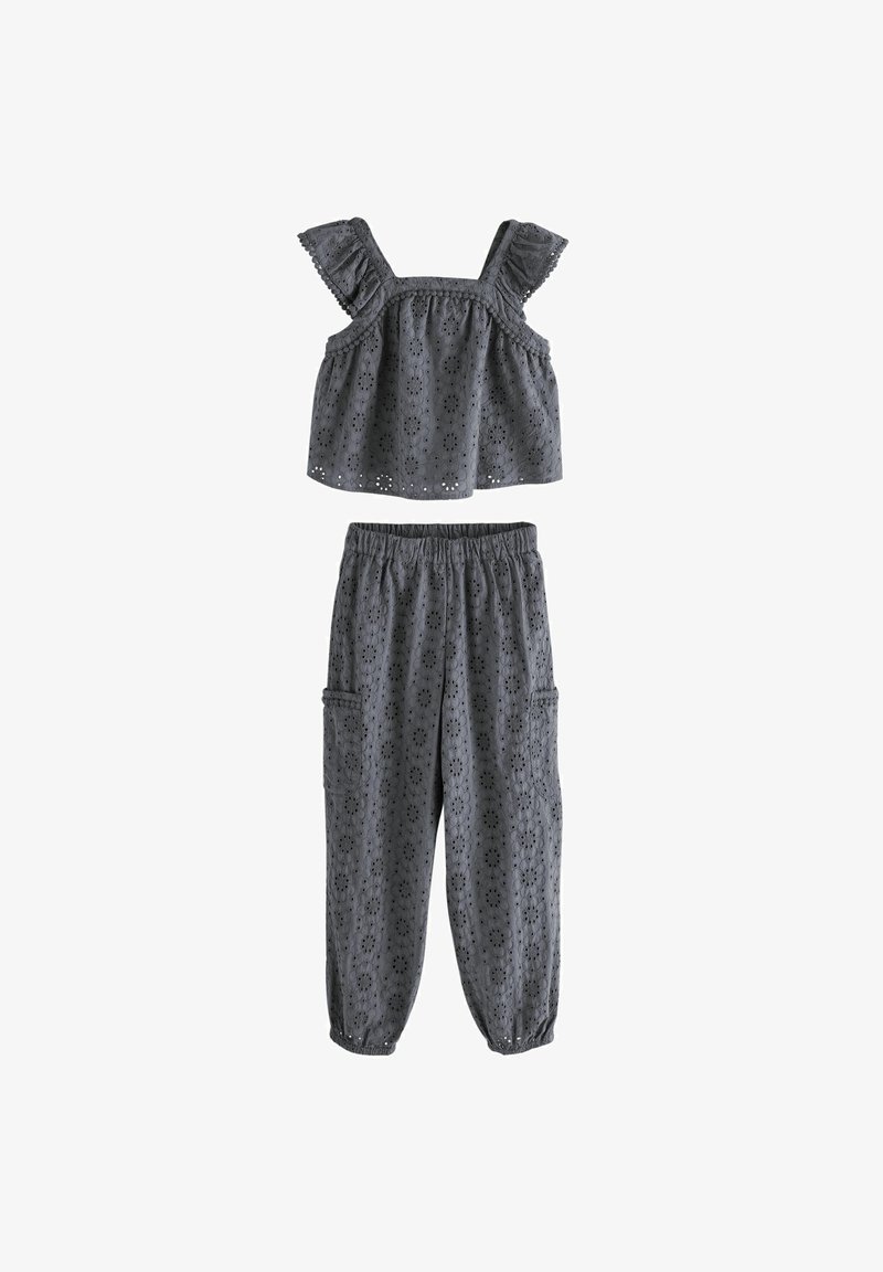 Grijze katoenen twee-delige set bestaande uit een mouwloos topje met geplooide schouderbanden en elastische broek met zijzakken en uitsnijdingen.