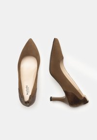 Scarpe con tacco alto in suede marrone con punta appuntita, caratterizzate da un accento di pelle di serpente marrone texturizzata sul tallone e un design con ritagli.