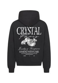 Czarna bluza z kapturem z dużym nadrukiem błyszczących diamentów oraz napisem "CRYSTAL Paris Jewelry & Timepieces" na plecach.