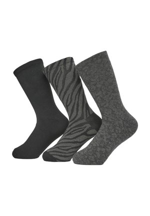Tre paia di calze: nere unite, nere con un motivo a strisce zebra e grigie scure con un design testurizzato. Tutte hanno polsini a coste.