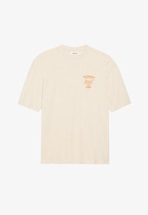 Beige t-shirt met korte mouwen, gemaakt van zachte stof, met een cartoonprint waarop het woord "YUMMY" in oranje staat, gelegen aan de linkerkant van de borst.