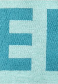Türkiser Badvorleger mit einer strukturierten Oberfläche und einem großen Großbuchstaben-Muster. Die Farben umfassen helle und dunkle Blautöne.