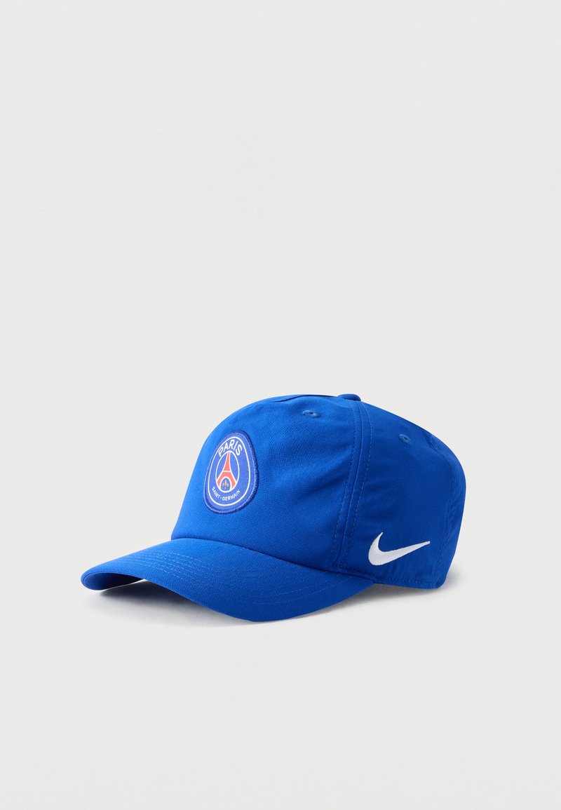 Μπλε καπέλο μπέιζμπολ με το λογότυπο της Paris Saint-Germain μπροστά και λευκό σήμα Nike στο πλάι, σε μονόχρωμο φόντο.